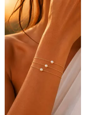 Bracelet Noëline – Double chaîne fine dorée et perle nacrée, bijou délicat de mariée